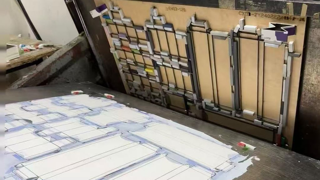 a die-cutting machine in operation cutting paper with a steel die, demonstrating what is die cutting and how die cutting works in packaging and printing.